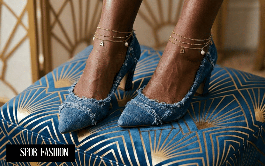 Close-up of pointed-toe high heels covered in upcycled blue denim with gold ankle chains.